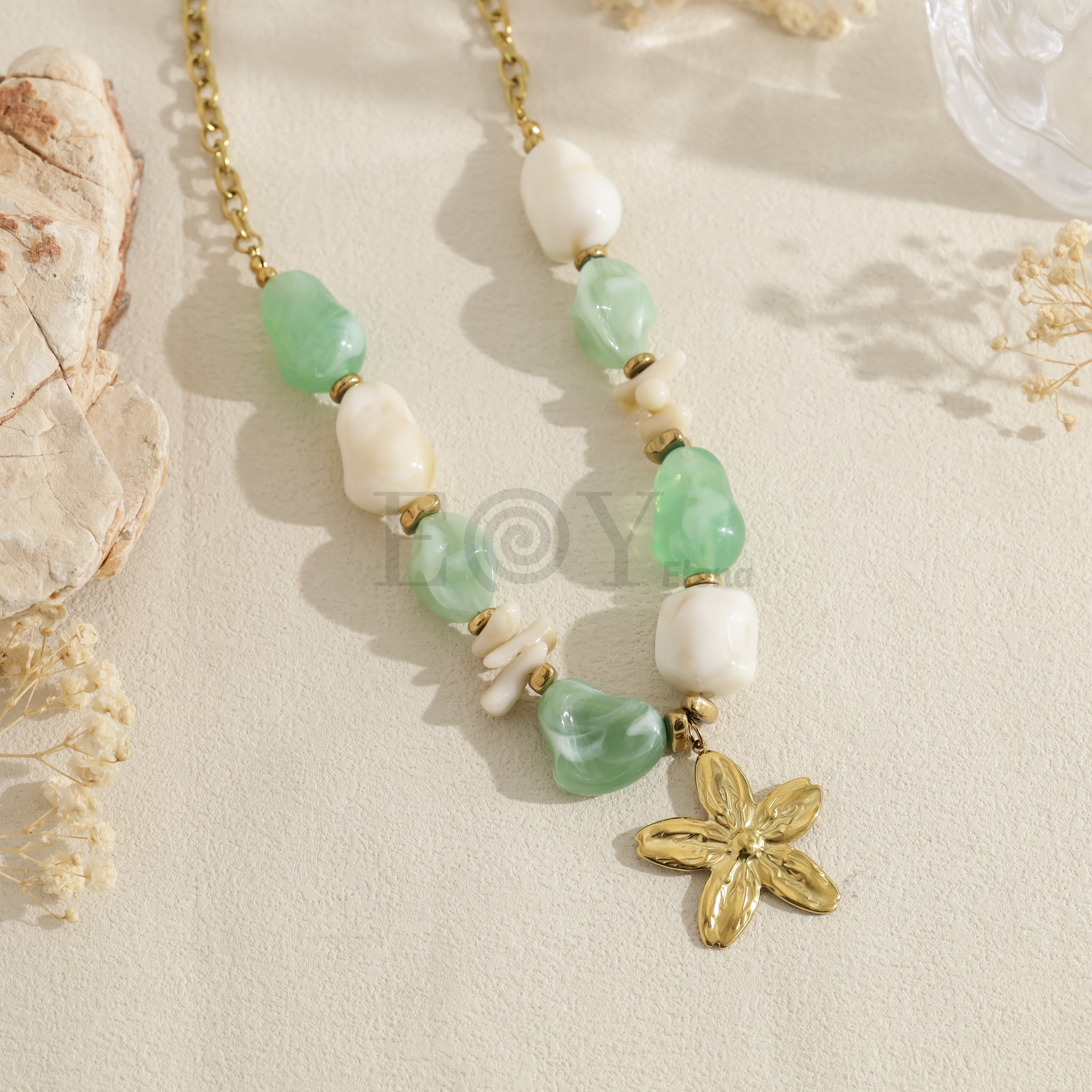 Collar con cuentas verdes y blancas y colgante de flor