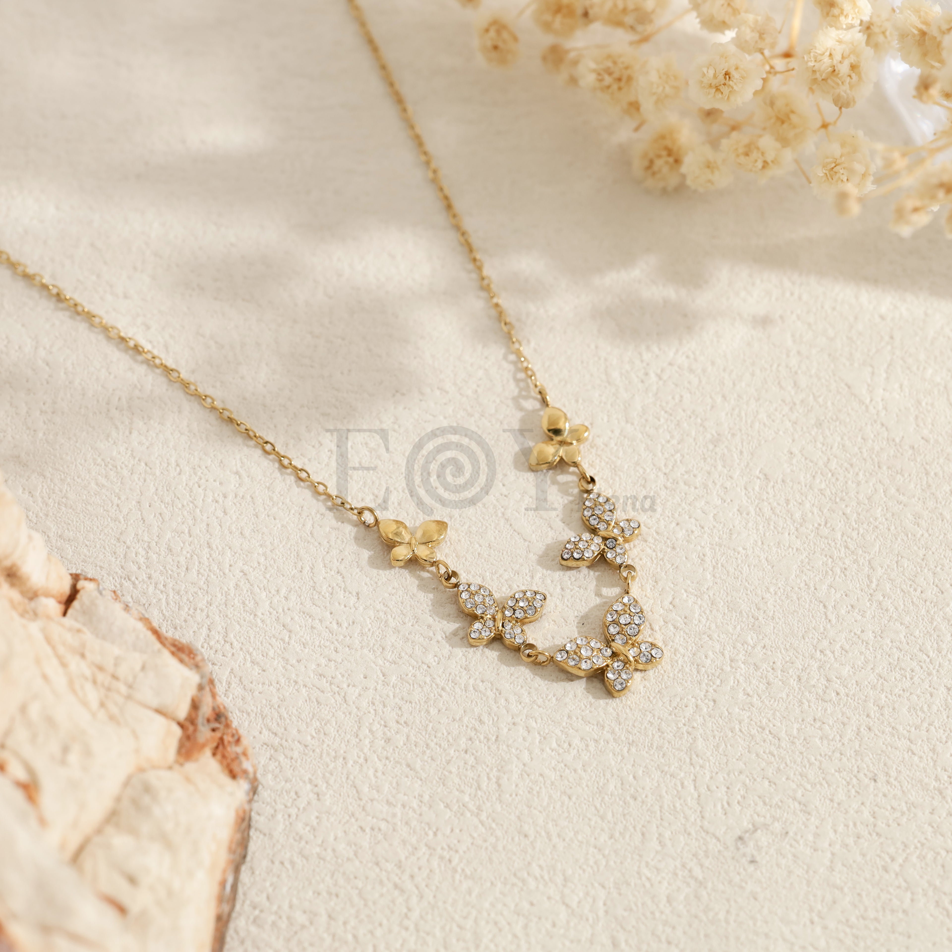 Collar dorado con mariposas brillantes