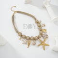 Collar con cadena de malla dorada y charms marinos