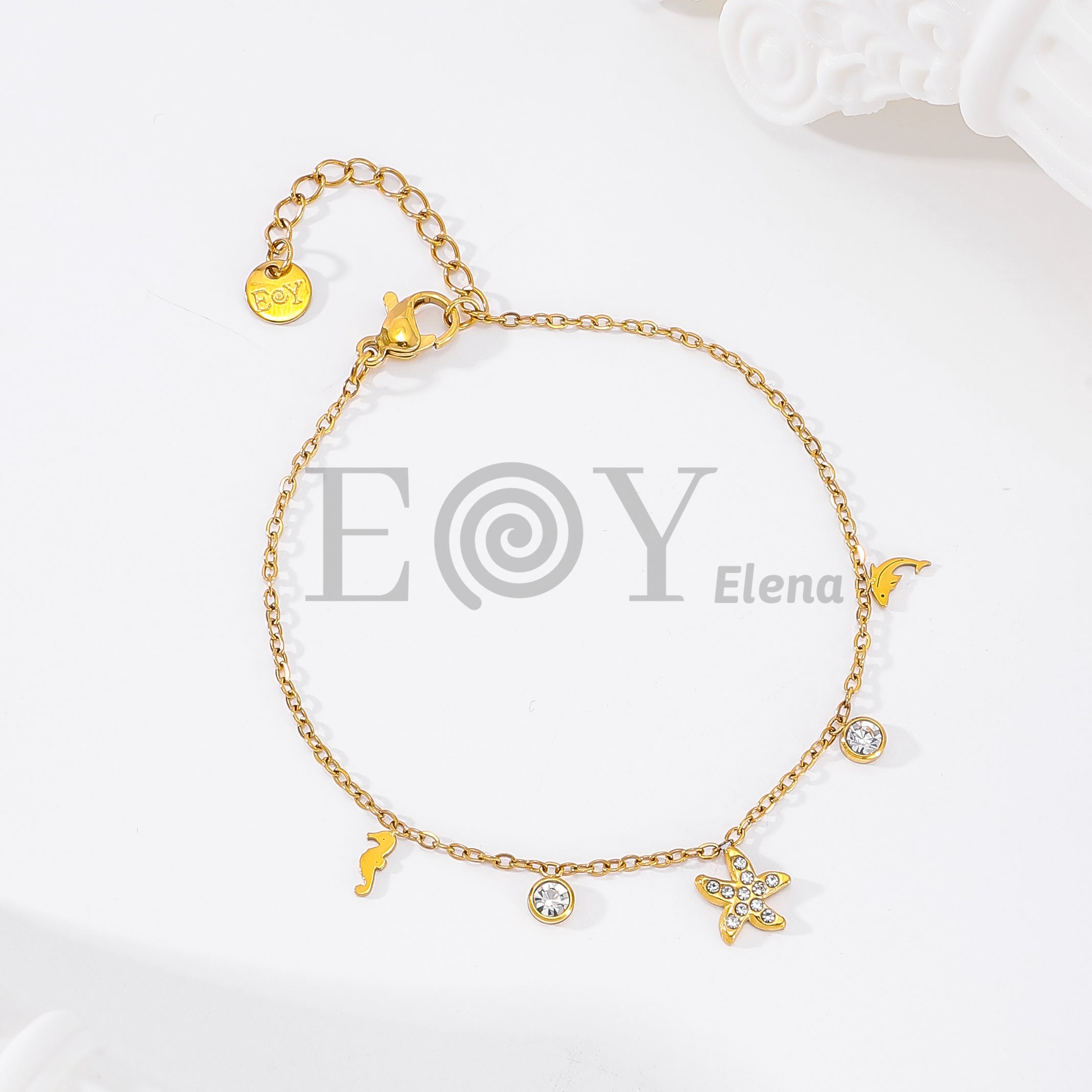 Pulsera de cadena dorada con colgantes de estrella de mar, delfines y circonitas