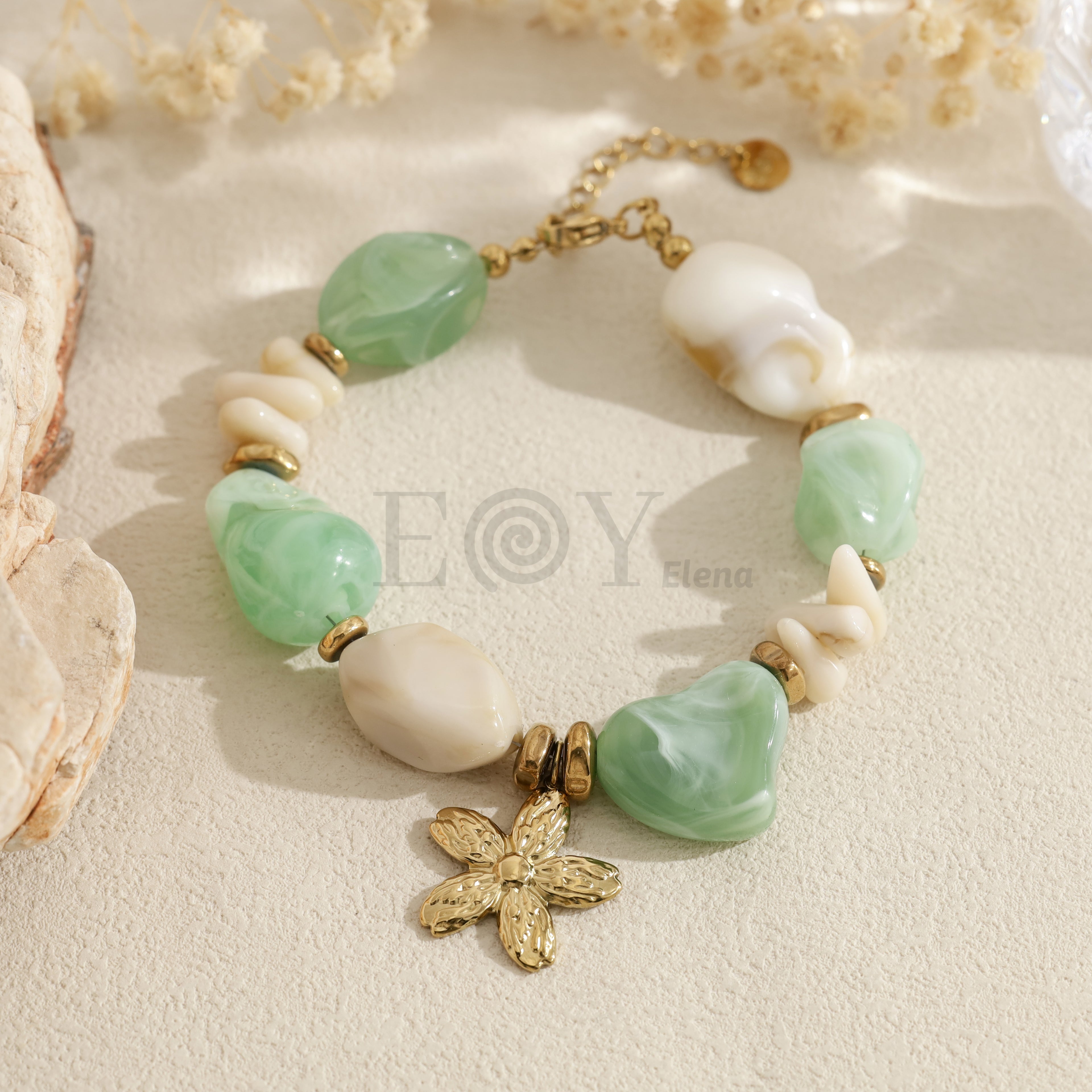 Pulsera con cuentas verdes y blancas y colgante de flor