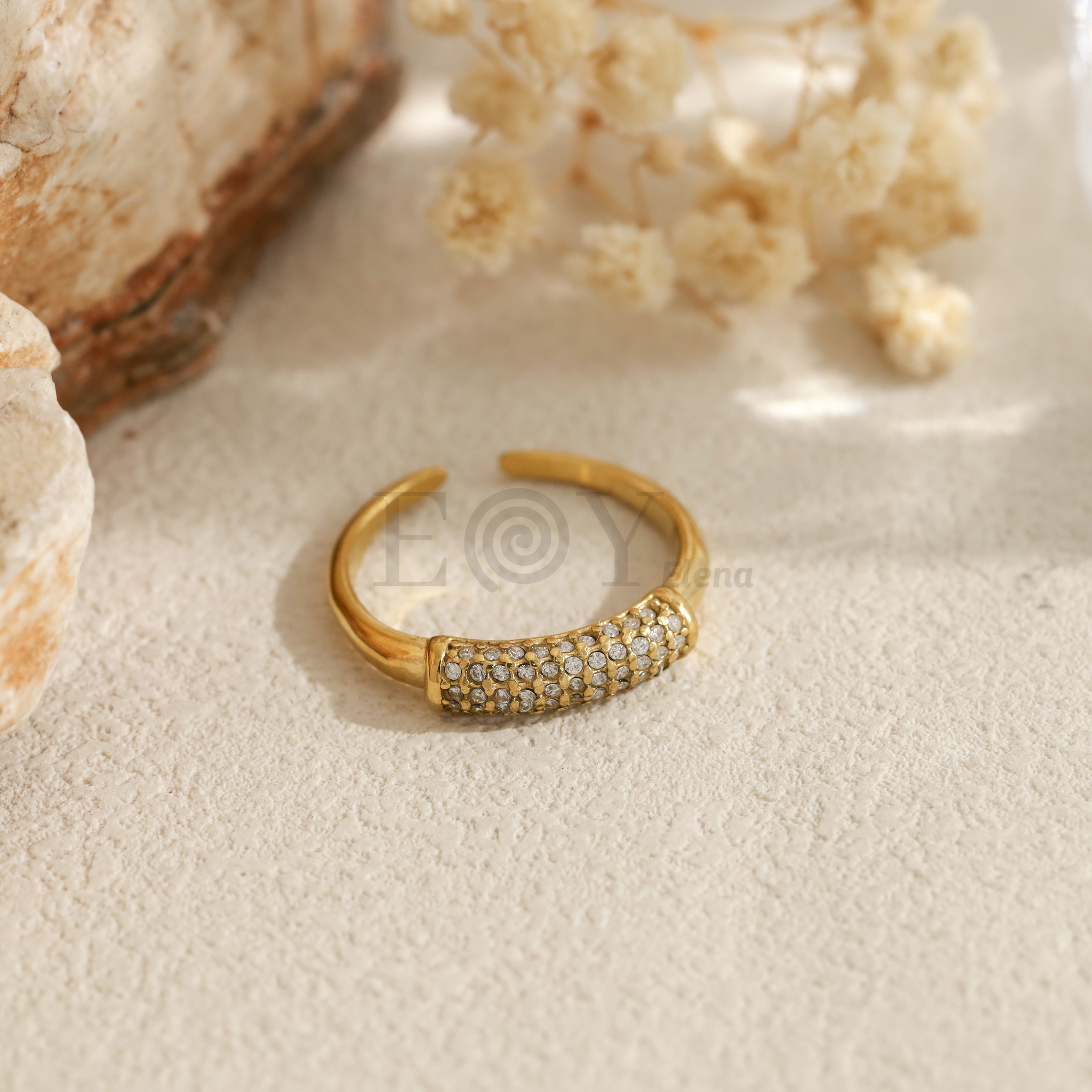 Anillo abierto con pieza frontal de piedras